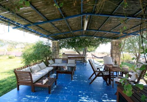 a patio with chairs and tables on a blue tile floor at Seaside, relaxing family house with playground! Villa Lavrys 4 in Marathi