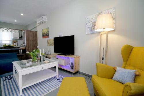 ein Wohnzimmer mit einem Sofa und einem TV in der Unterkunft Seaside, relaxing family house with playground! Villa Lavrys 4 in Marathi