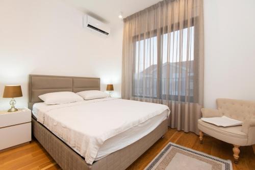 een slaapkamer met een groot bed en een raam bij Apartment Gardenija in Tivat
