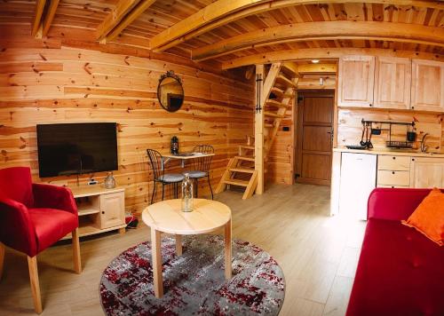 una sala de estar con TV en una cabaña de madera en Apartmani i kuće Moje selo Šćepanović en Kolašin