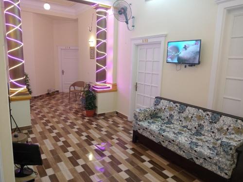 a living room with a couch and a tv on the wall at New One Hotel in Cairo
