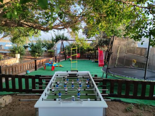 a ping pong table in front of a playground at Seaside, relaxing family house with playground! Villa Lavrys 4 in Marathi