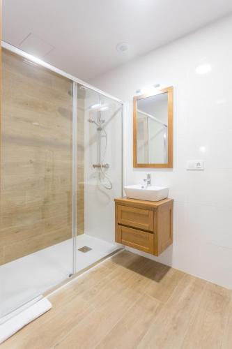 a bathroom with a shower and a sink and a mirror at Casa da Ponte de Penas in Melide