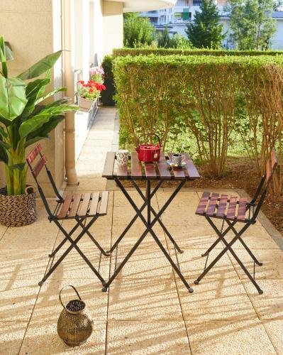 - une table de pique-nique et 2 chaises sur la terrasse dans l'établissement Appartement Wakandais-proche Disney, parking & wifi, à Montévrain