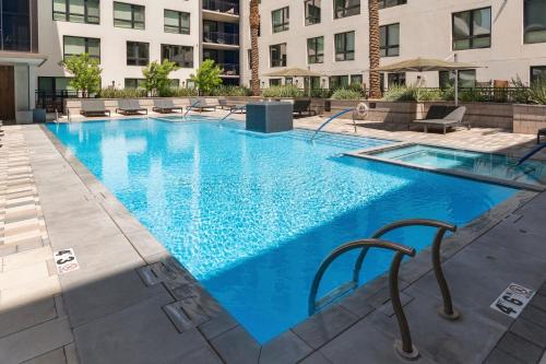 a large blue swimming pool with chairs and buildings at Kasa Scottsdale Quarter Phoenix in Scottsdale