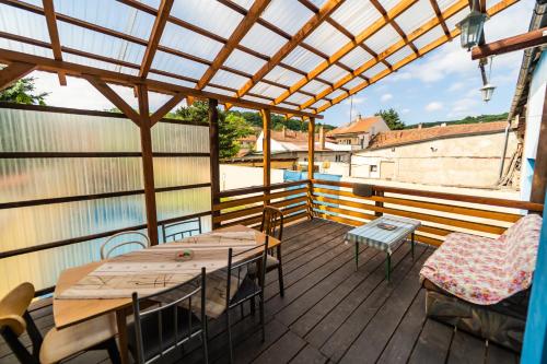 un patio con mesas y sillas en una terraza de madera en Dum Slunicko en Klobouky u Brna