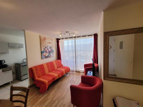 a living room with an orange couch and a chair at Atacama Valley 10 in Copiapó