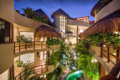 un edificio de apartamentos con un patio con plantas en Maya Villa Condo Hotel and Beachclub en Playa del Carmen