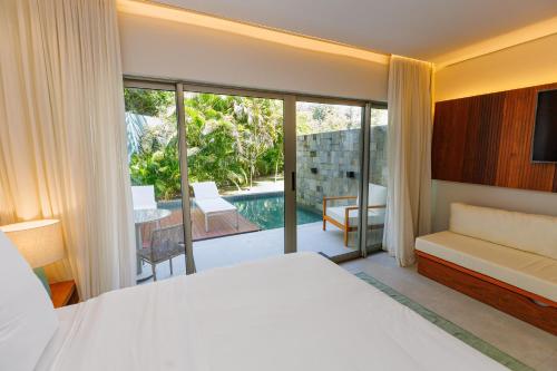 a bedroom with a bed and a view of a pool at HostPB-DECK molhado privativo-Melhor LOCALIZAÇÃO de Pipa in Pipa