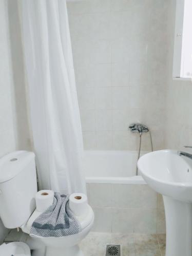 a white bathroom with a toilet and a sink at THREE GRACES Apartments ZAKYNTHOS TOWN in Zakynthos Town