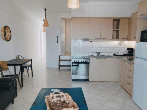 a kitchen and living room with a table and a stove at THREE GRACES Apartments ZAKYNTHOS TOWN in Zakynthos Town
