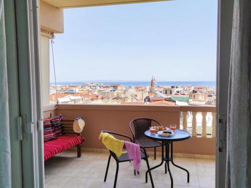 a balcony with a table and chairs and a view at THREE GRACES Apartments ZAKYNTHOS TOWN in Zakynthos Town