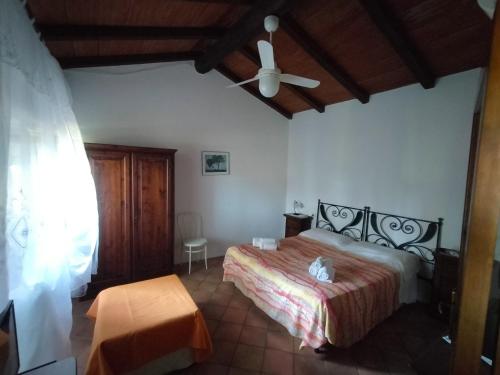 - une chambre avec un lit et un ventilateur de plafond dans l'établissement Agriturismo Bio Pian Dei Casali, à Saturnia