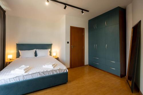 a bedroom with a large bed and blue cabinets at Luxury Art 4 Apartment in Blagoevgrad