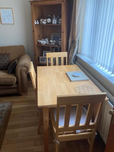 a wooden table and chairs in a room with a window at Deeleview apartment in Lifford
