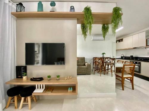 Una sala de estar y una cocina con mesa y sillas. en Apto 80m da Praia Grande vista mar!, en Governador Celso Ramos