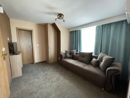 a living room with a couch and a window at Pensiunea Dunarea in Moldova Nouă