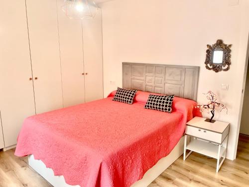 a bedroom with a bed with a red bedspread at In Love Zamora in Zamora