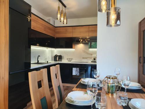 a dining room with a table and chairs and a kitchen at Apartamenty Ski & Fun Spokojna in Wisła
