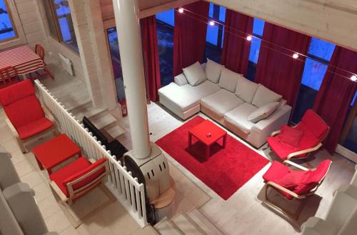 una vista aérea de una sala de estar con un sofá blanco y sillas rojas en Holiday Cabin Kerimaa 90, en Kerimäki