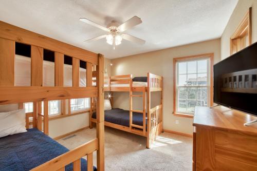 a bedroom with two bunk beds and a flat screen tv at Deja Blue 917 in Frisco