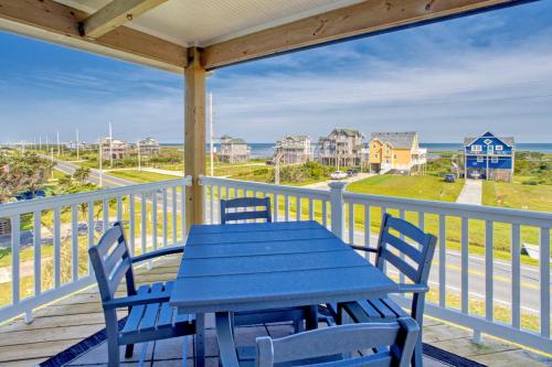 a blue table and chairs on a porch with a view of the ocean at Deja Blue 917 in Frisco