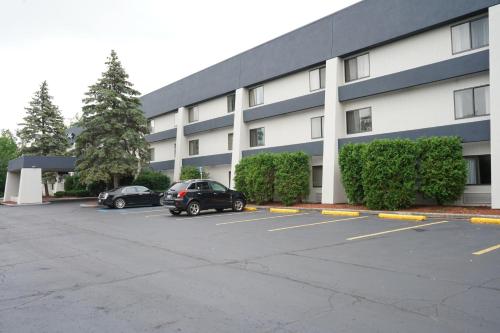 a building with two cars parked in a parking lot at Baymont by Wyndham Bridgeport/Frankenmuth in Bridgeport
