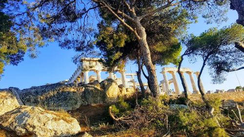 a temple on top of a hill with trees at Possidon in Agia Marina Aegina