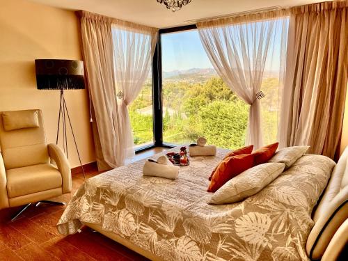 sypialnia z łóżkiem i dużym oknem w obiekcie Grandes apartamentos de lujo en una casa con piscina en Javea w mieście Montgo