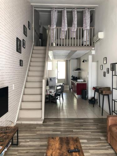 una sala de estar con escaleras que conducen a un loft en Les couleurs de Balaruc Les Bains en Balaruc-les-Bains