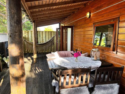 einen Tisch und Stühle auf der Veranda einer Hütte in der Unterkunft Chalet aan de Rotte in Rotterdam