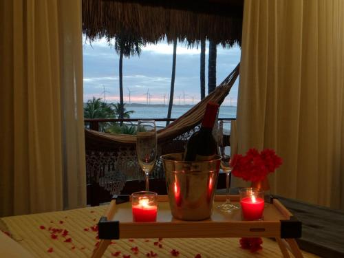 a table with candles and a bottle of wine and glasses at Junduh Brasil Pousada e Restaurante in Icaraí