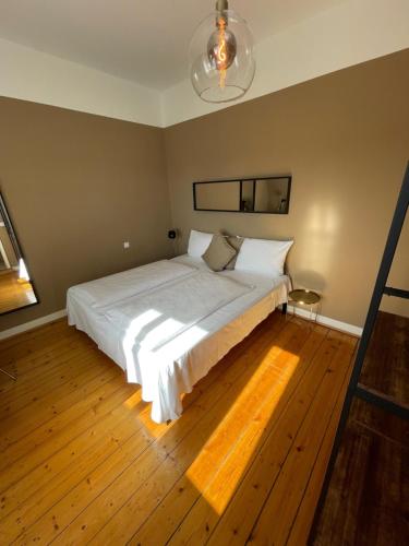a bedroom with a large white bed and wooden floors at AUERSTEIN-Hotels auerstein & auerstein-mono in Heidelberg