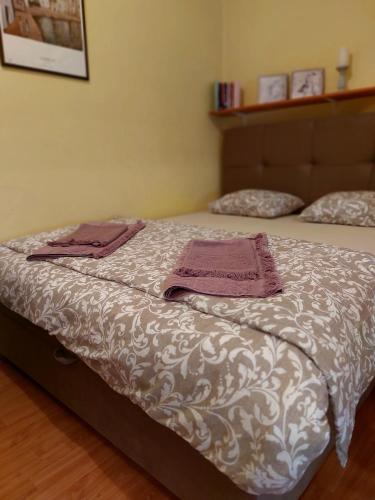 a bed with two towels on top of it at Apartman Nikos in Zadar