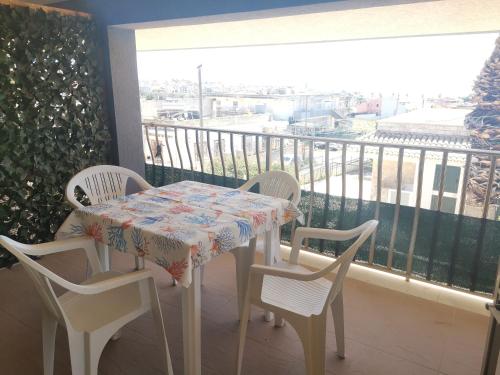 un tavolo e sedie su un balcone con tavolo e finestra di Casa Vacanze Tavolara 2 a Donnalucata