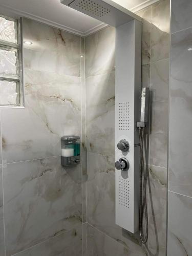 a bathroom with a shower with a glass door at ATLANTIS APARTMENTS in Artemida
