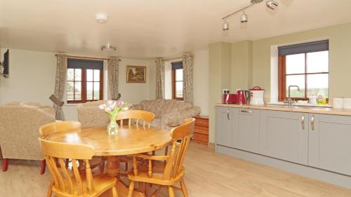 a kitchen and living room with a table and chairs at Parkfields Barns Self Catering Accommodation in Buckingham