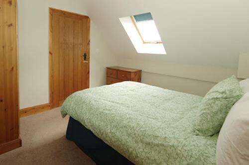 a bedroom with a bed and a skylight at Parkfields Barns Self Catering Accommodation in Buckingham