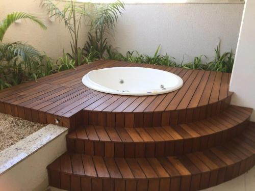 a bath tub sitting on top of a wooden deck at Lounge 22 Praça do Sol Tamandaré Shopping Bouganville Jotas Bartolomeu Cartório Artiaga Hospital do Coração Annis Rassi Íbis Holliday Rua 9 Feira da Lua Bodytech Marista Madalena Bahrem Nord23 Pão de Açúcar Alameda das Rosas Zoológico in Goiânia