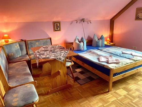 a bedroom with a bed and a table and chairs at Pension zur Heiligen Krone in Mauterndorf