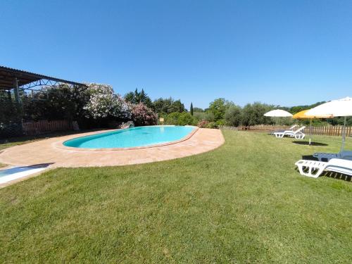 a swimming pool in a yard with a grass field at Agriturismo Bio Pian Dei Casali in Saturnia
