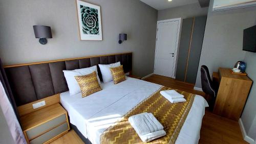 a small bedroom with a bed with two towels on it at Falcon Boutique Hotel in Tbilisi City