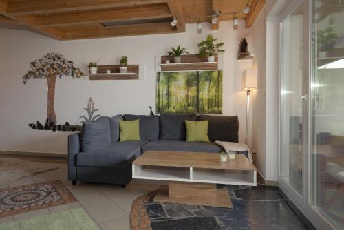 - un salon avec un canapé bleu et une table dans l'établissement feworld living - near Salzburg city, à Freilassing