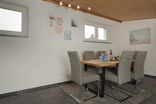 - une salle à manger avec une table et des chaises en bois dans l'établissement feworld living - near Salzburg city, à Freilassing