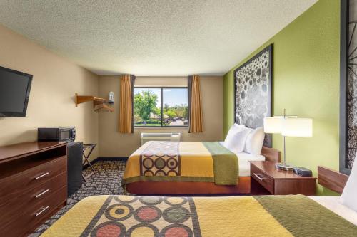 ein Hotelzimmer mit 2 Betten und einem TV in der Unterkunft Super 8 by Wyndham Ankeny/Des Moines Area in Ankeny