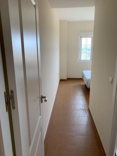 a room with a door and a hallway with a bed at Apartamento Costa Esuri in Ayamonte