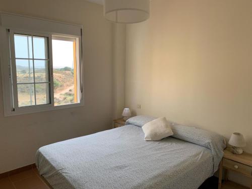 a bedroom with a bed and a window at Apartamento Costa Esuri in Ayamonte