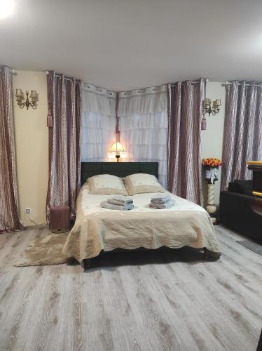 a bedroom with a bed with wooden floors and curtains at Gite Luxury***** avec Bar à Soultzeren in Soultzeren