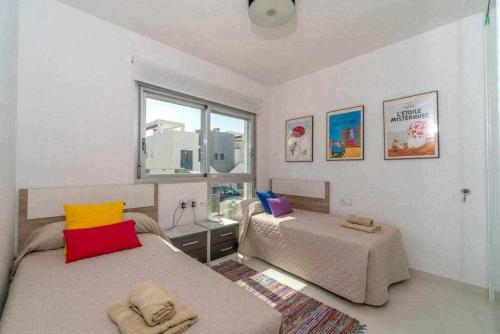 Un dormitorio con dos camas y una ventana. en Espanhouse Caroline bungalow, en Torrevieja