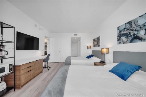 哈兰代尔海滩Chic Beach Studio Walk to Shore Sleeps 4 -14B的一间有两张床和一台平板电视的酒店房间